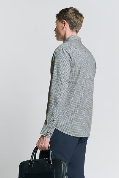 Chemise à manches longues bleue de NO EXCESS, avec un motif géométrique subtil, portée avec un pantalon bleu marine et une sacoche noire.