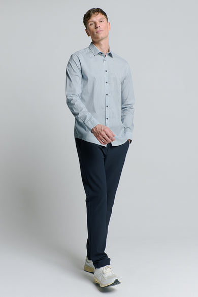 Chemise à manches longues bleue de NO EXCESS, avec motif géométrique subtil, portée avec un pantalon bleu marine et des baskets claires.