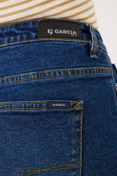 Short bleu en denim par GARCIA, détail de couture jaune ocre et étiquette de la marque.