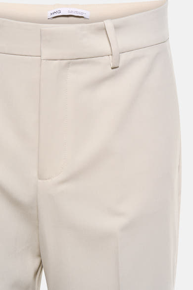 Beige kostuumbroek van MANGO, taillebanddetail met riemlussen en gulp.