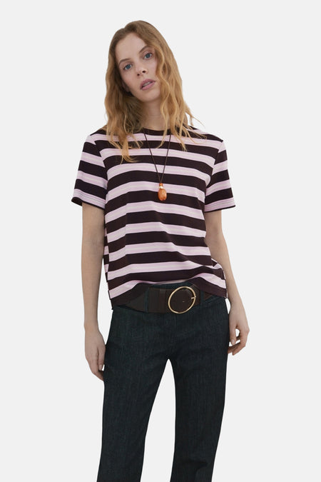 T-shirt à manches courtes multicolore de MANGO, à rayures horizontales, porté avec un pantalon bleu foncé et une ceinture marron.
