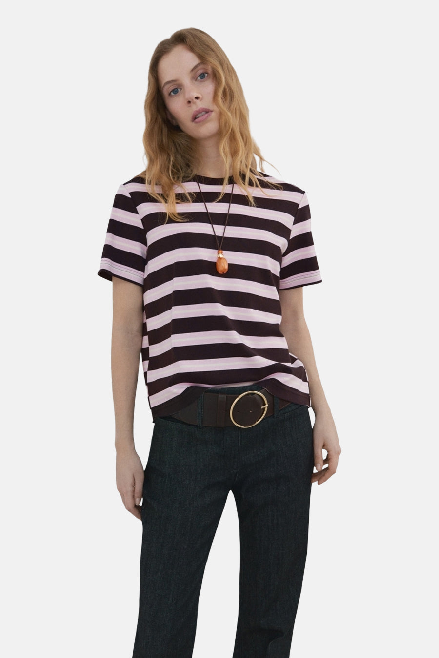 Multikleurig T-shirt met korte mouwen van MANGO, roze en zwart gestreept, gedragen met een donkere broek.