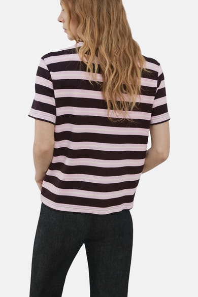 T-shirt à manches courtes multicolore de MANGO, rayé rose et noir, porté avec un pantalon foncé.