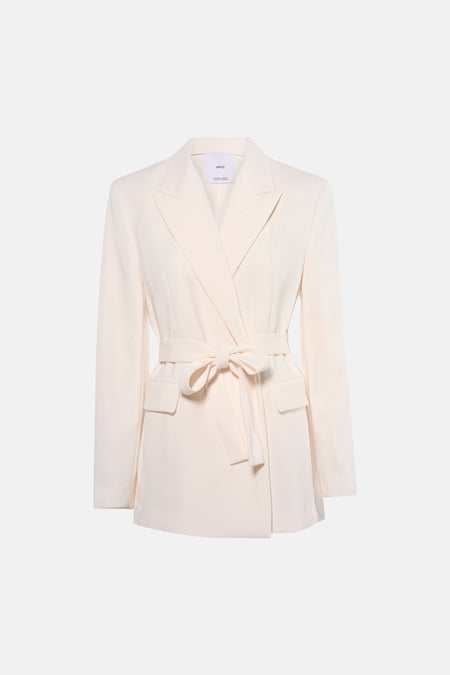 Ecru blazer van MANGO, met ceintuur in de taille, gedragen met een zwarte broek en naaldhakken.