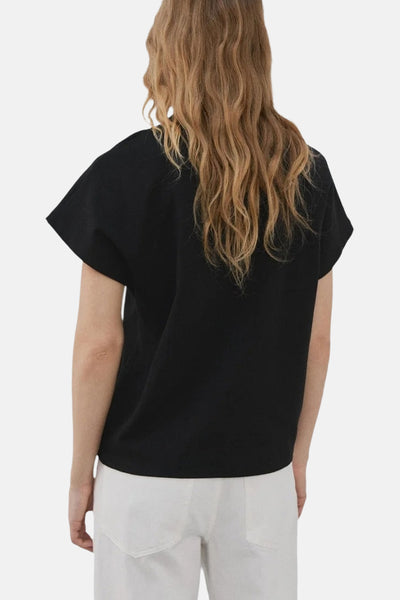 Top noir de MANGO, porté avec un pantalon blanc, visible de dos.