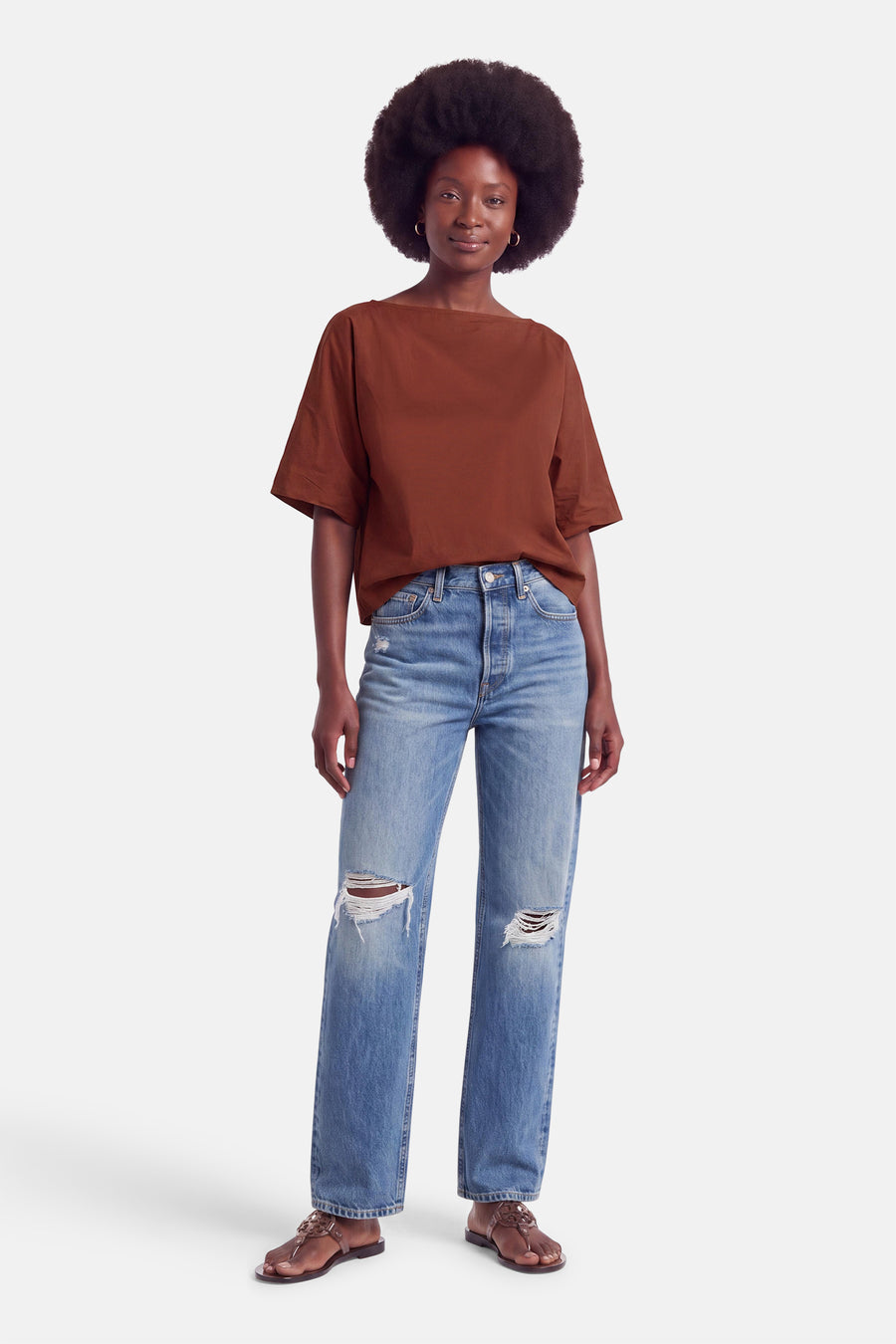 Blouse à manches courtes couleur brique par Terra di Siena, coupe ample, portée avec jeans déchirés et sandales, vue de face.