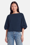 Blouse bleue à manches courtes par Terra di Siena, coupe ample avec col bateau, portée avec jeans délavés