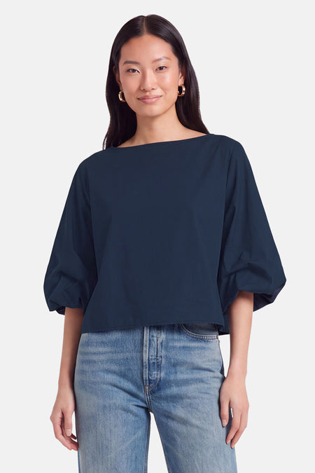 Blouse bleue à manches courtes par Terra di Siena, coupe ample avec col bateau, portée avec jeans délavés