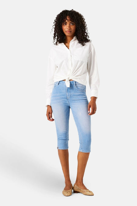 Jean denim bleu clair de GARCIA, porté avec une chemise blanche nouée.
