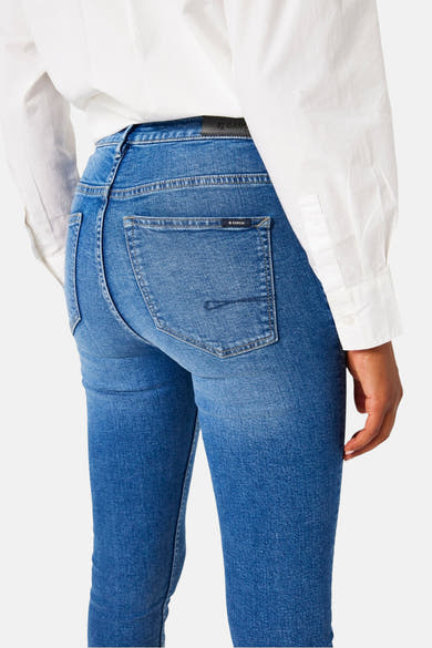 Jean bleu moyen en denim de GARCIA, avec une poche arrière ornée d'une couture horizontale, porté avec une chemise blanche.