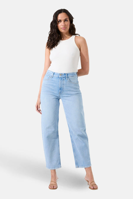 Jean bleu clair en denim de GARCIA, porté avec un débardeur blanc et des talons hauts.