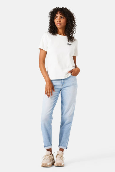 Jean Mom in lichte blauwe denim van GARCIA, gedragen met een eenvoudig wit t-shirt en beige sportshoes.