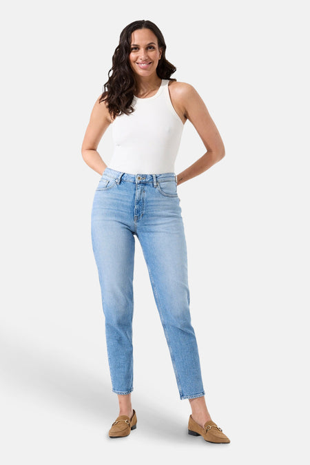 Jean Mom taille haute en denim bleu moyen de GARCIA, porté avec un débardeur blanc et des mocassins marron.