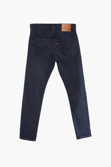 Jean tapered bleu moyen de Levi's®, avec une étiquette en cuir sur la ceinture et des poches arrière.
