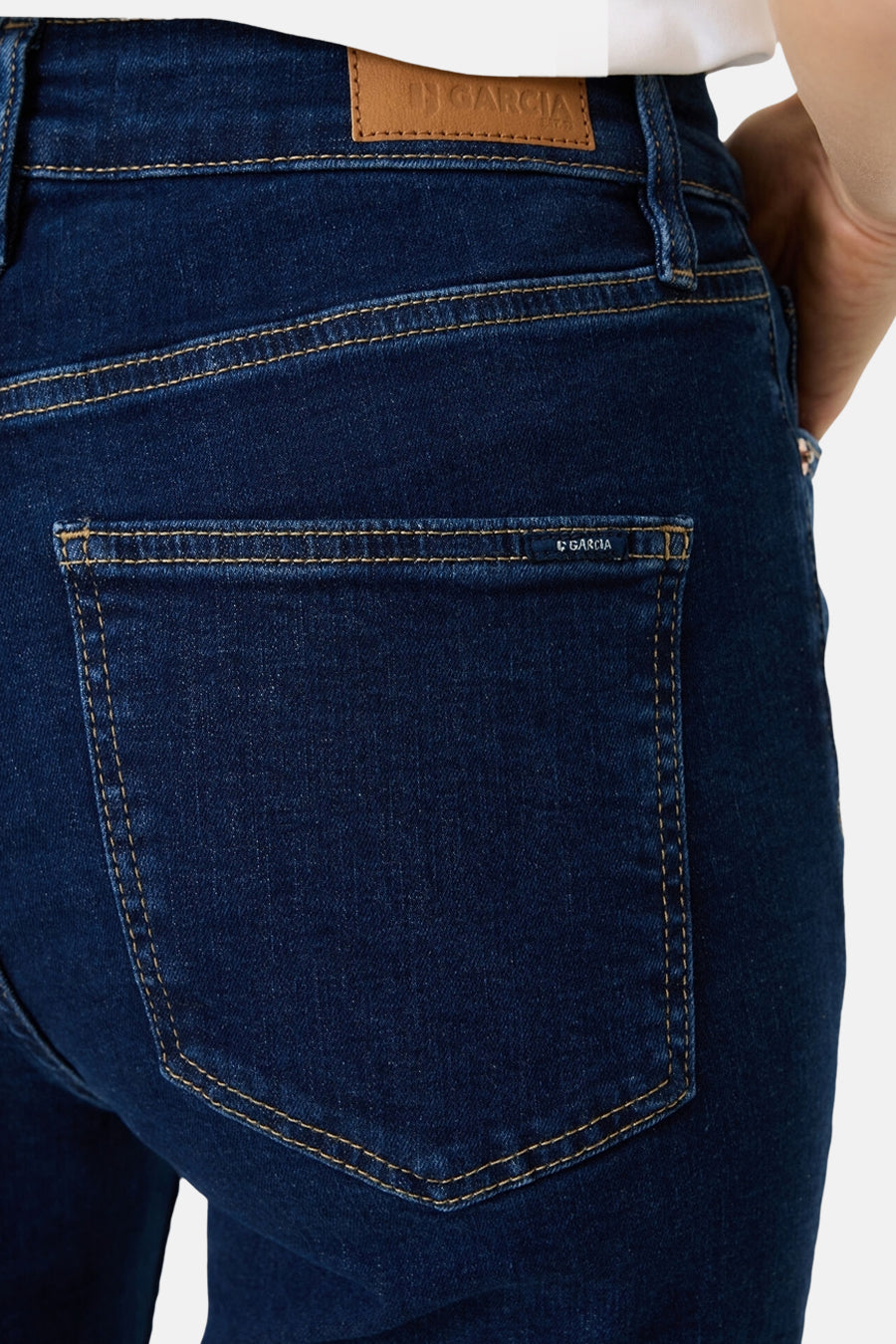 Dark blue flared jeans by Garcia with brown stitching and back pocket branding, close-up rear view