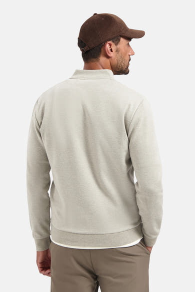 Beige trui van NO EXCESS van achteren gezien, gedragen met een bruine broek en een pet.