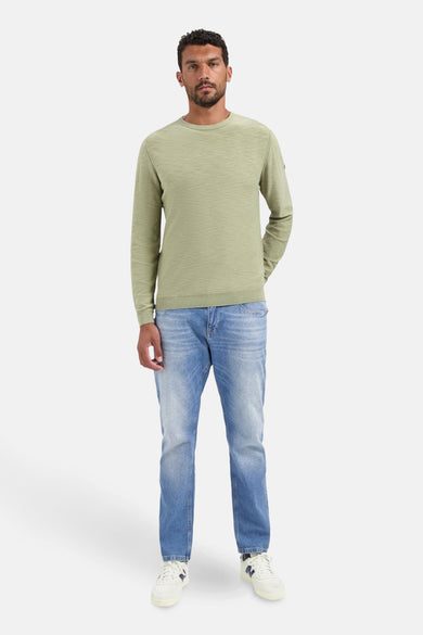 Pull à col rond vert de NO EXCESS, porté avec un jean bleu et des baskets blanches.
