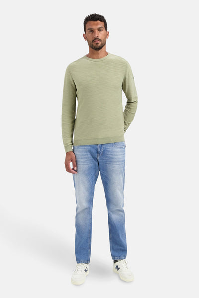 Pull à col rond vert de NO EXCESS, porté avec un jean bleu et des baskets blanches.
