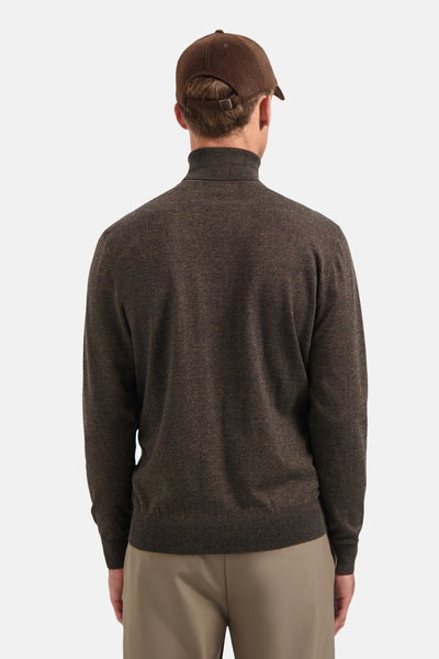 Pull à col roulé taupe de No Excess, porté avec une casquette marron et un pantalon beige.