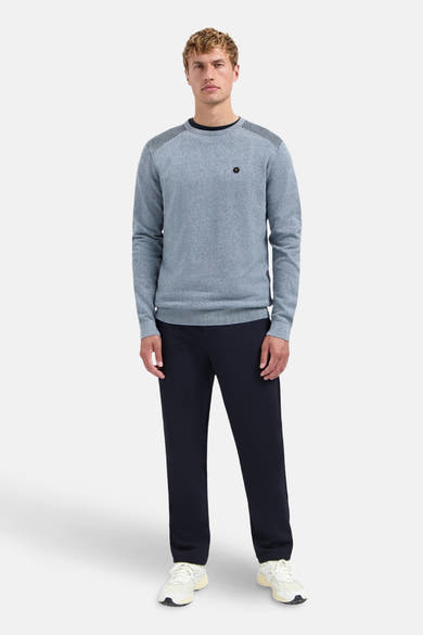 Ronde hals trui blauw van NO EXCESS met patroon op de schouders, gedragen met een marineblauwe broek.