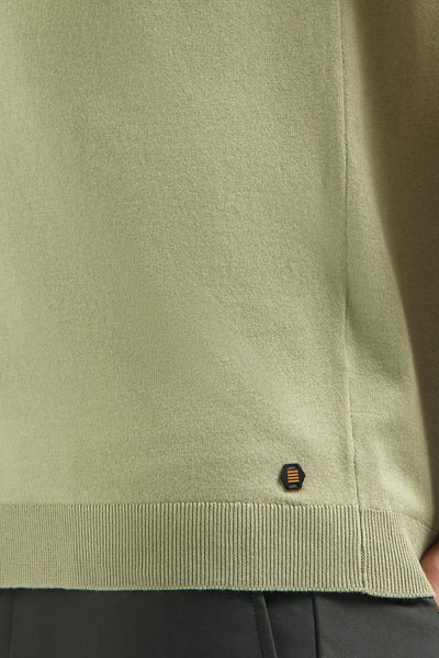 Pull vert de NO EXCESS, avec un badge hexagonal décoratif sur le bord côtelé.