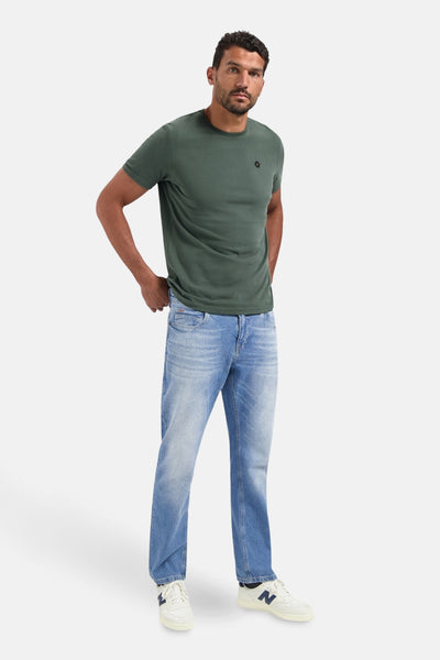 Kaki T-shirt met korte mouwen van NO EXCESS, gedragen met een verbleekte spijkerbroek en witte sneakers.