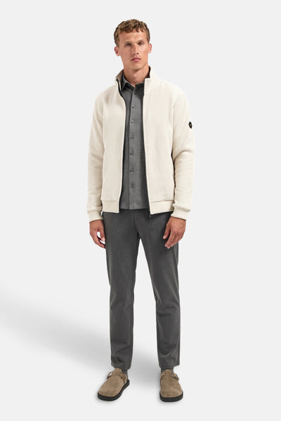 Grijze blouse met lange mouwen van NO EXCESS, gedragen met een vest met rits en een grijze broek.