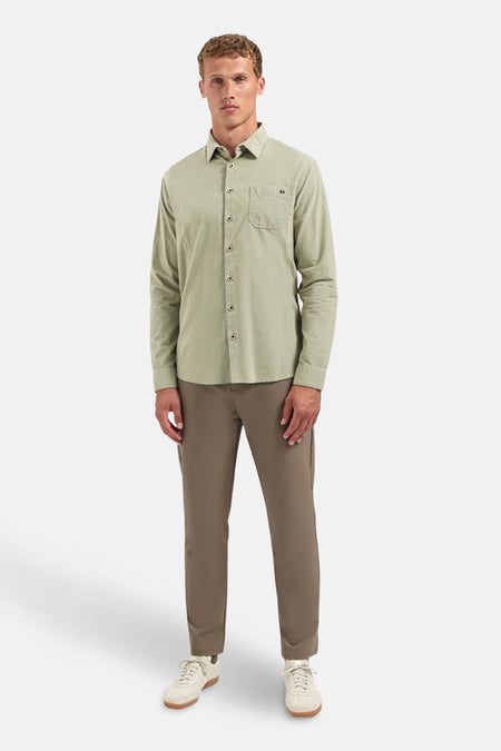 Groen overhemd met lange mouwen van NO EXCESS, met een borstzak en gedragen met een bruine broek en witte sneakers.
