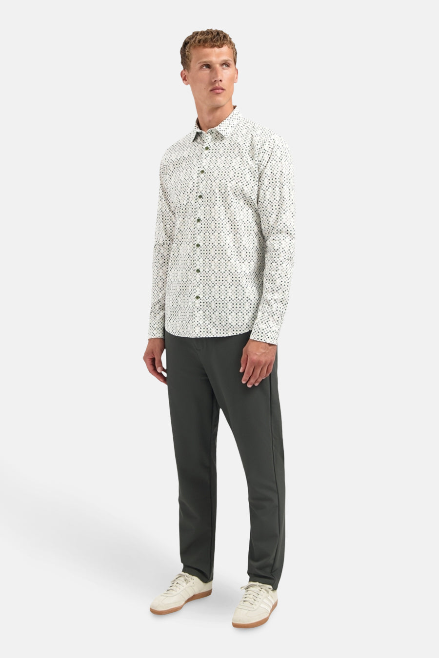 Chemise à manches longues multicolore de NO EXCESS, à motif géométrique, portée avec un pantalon et des baskets.
