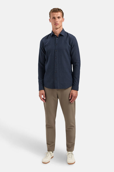 Blauw overhemd met lange mouwen van NO EXCESS, met subtiele patronen, gedragen met een lichtbruine broek en witte sneakers.