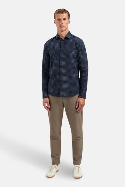 Blauw overhemd met lange mouwen van NO EXCESS, met subtiele patronen, gedragen met een lichtbruine broek en witte sneakers.