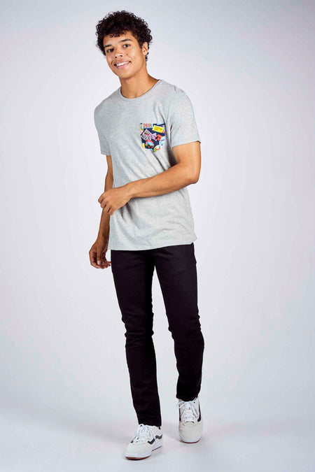 Jean fuselé noir de Levi's®, porté avec un t-shirt gris à poche imprimée et des baskets blanches.
