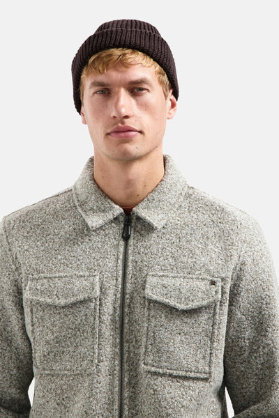 Veste gris chiné par NO EXCESS, avec fermeture éclair et poches plaquées, portée avec un bonnet marron.
