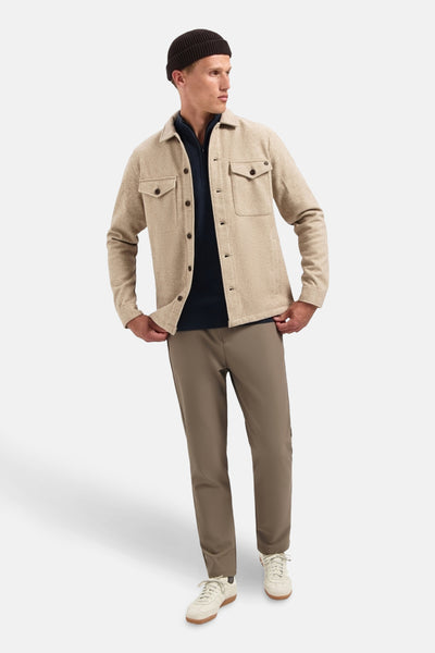 Beige hemd van No Excess met borstzakken, gedragen over een marineblauwe trui en een bruine broek.