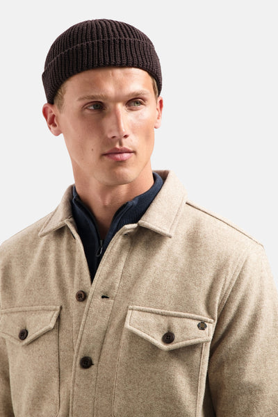 Chemise beige de NO EXCESS, portée sur un sous-pull bleu marine, avec un bonnet brun.