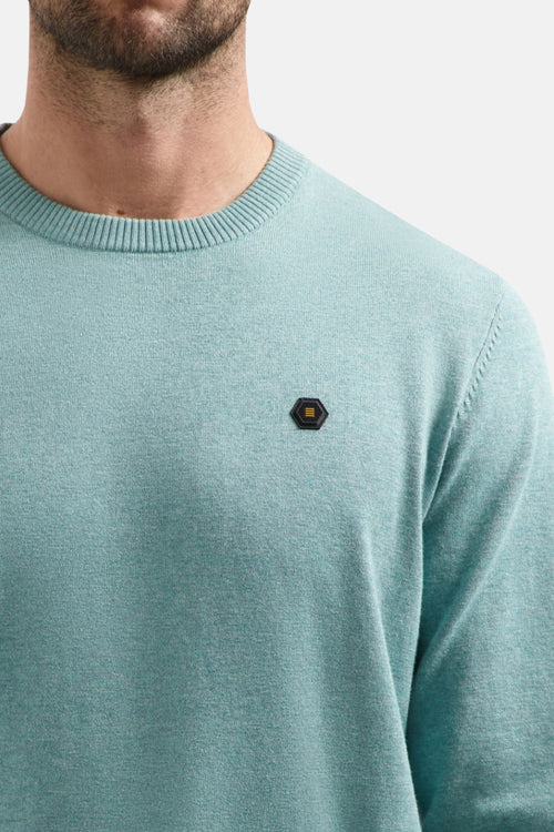 Pull à col rond bleu de NO EXCESS, avec un patch hexagonal sur la poitrine.