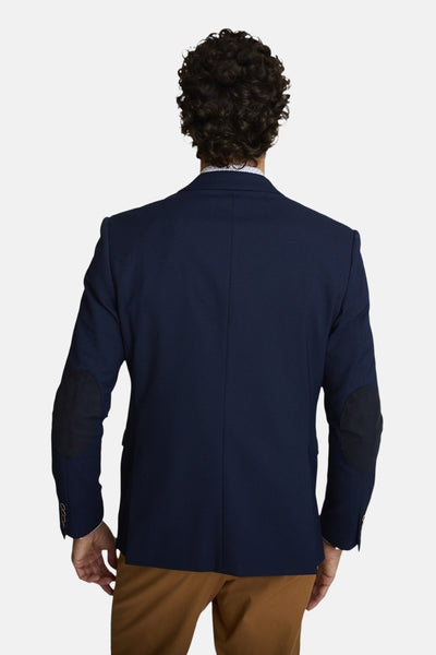 Blauwe blazer van DELAHAYE, met elleboogstukken, gedragen met een lichtbruine broek, achteraanzicht.
