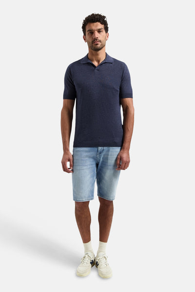 Pull bleu de NO EXCESS, porté avec un short en jean et des baskets blanches.