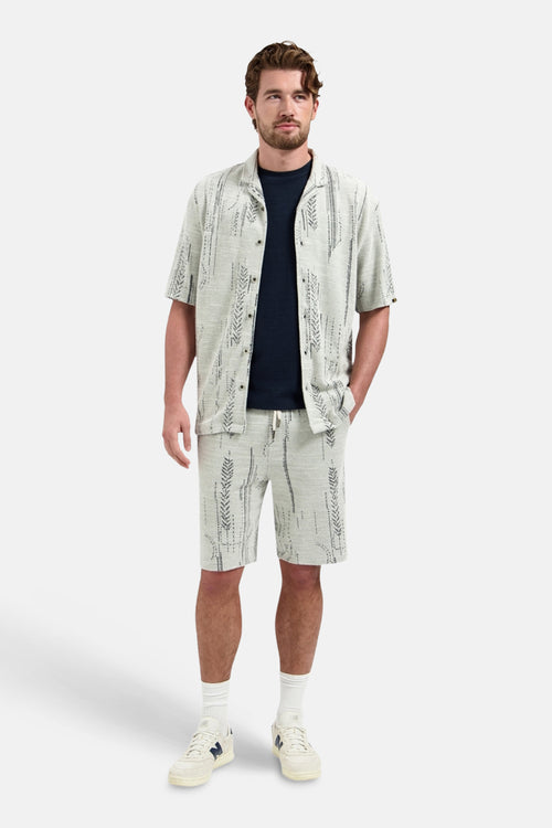 Blauw T-shirt met korte mouwen van NO EXCESS, gedragen onder een overhemd met grafische print en een bijpassende korte broek.