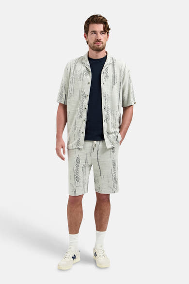 Blauw T-shirt met korte mouwen van NO EXCESS, gedragen onder een overhemd met grafische print en een bijpassende korte broek.