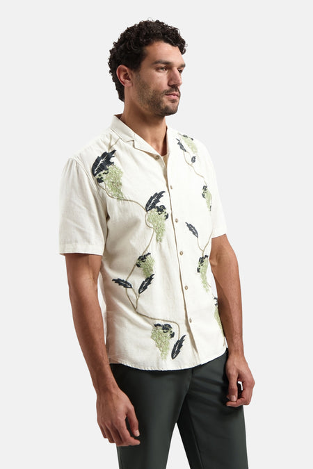 Chemise à manches courtes multicolore de NO EXCESS avec motif brodé texturé de grappes vertes et feuilles foncées.
