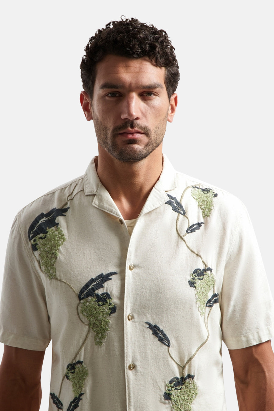 Chemise à manches courtes multicolore de la marque NO EXCESS avec motifs brodés de grappes de raisin vertes et de feuilles bleu marine.