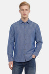 Chemise bleue à manches longues de NO EXCESS, à fines rayures verticales blanches et boutons dorés, portée avec un jean foncé.