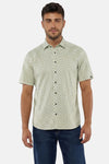 Chemise à manches courtes verte de NO EXCESS à motif hexagonal noir, portée par un homme avec un jean.