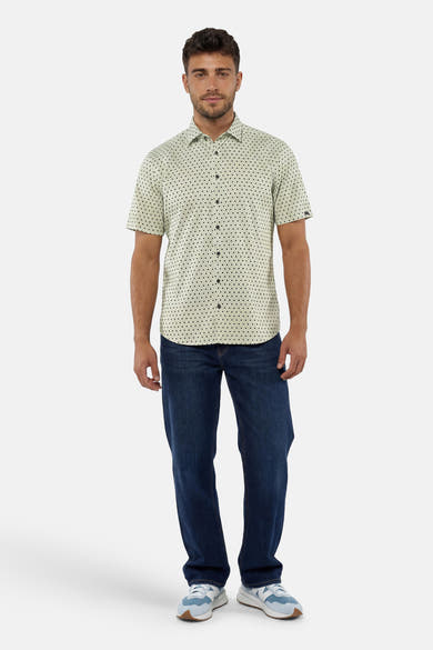 Chemise à manches courtes verte de NO EXCESS à motifs de cercles noirs, portée avec un jean.