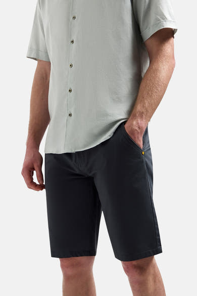 Kort antracietgrijs short van NO EXCESS, met een geel detail op de zak, gedragen door een man in een lichtgroen overhemd.