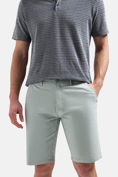 Korte effen short van NO EXCESS, met gouden knoop en klinknagel, gedragen met een bedrukt poloshirt.