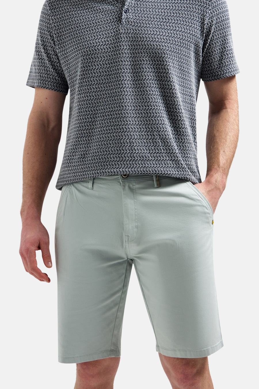 Korte effen short van NO EXCESS, met gouden knoop en klinknagel, gedragen met een bedrukt poloshirt.