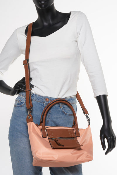 Sac à bandoulière orange de Tamaris avec bandoulière marron, porté sur un mannequin en jean et t-shirt blanc.
