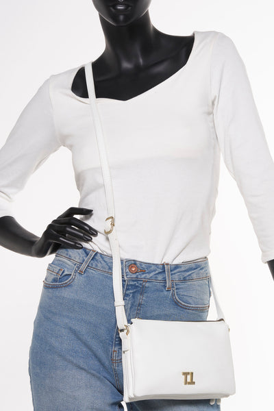Witte schoudertas van Tamaris gedragen met een high-waisted jeans en een witte top met lange mouwen.